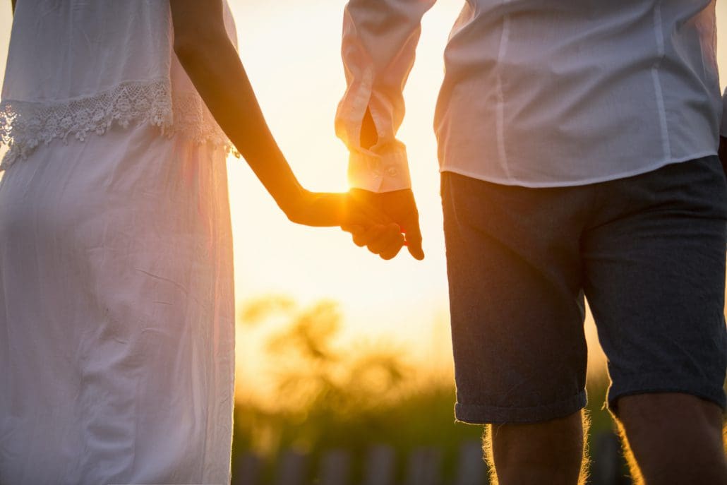 Married Couple holding hands at sunset